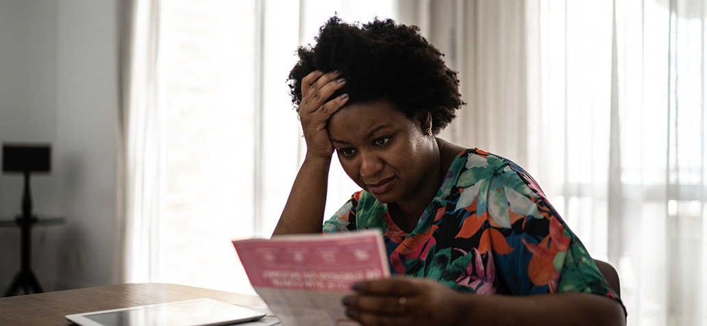 Worried woman looking at financial bills at home