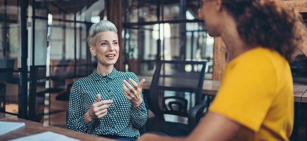 two women conversing in the workplace