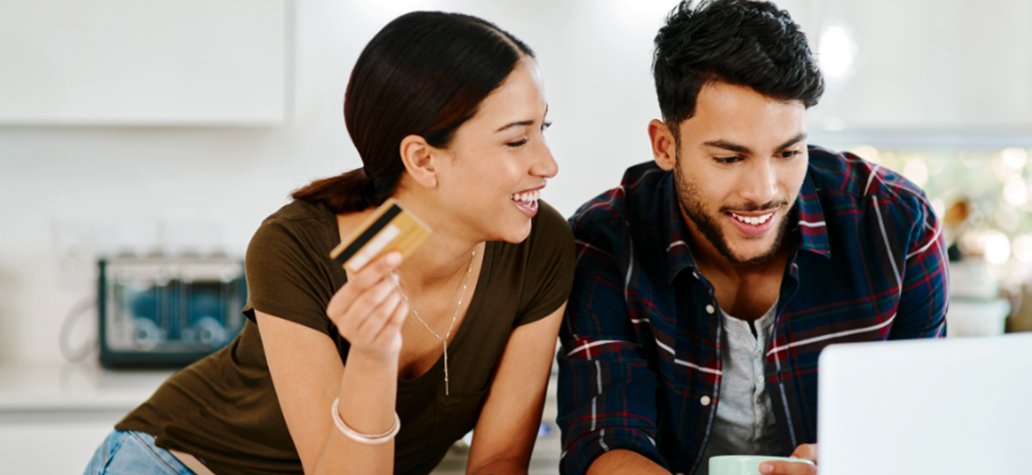 Young adults looking at a laptop while making financial decisions together.