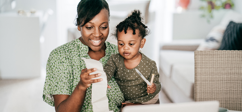 Mother holding young child assessing her financial well-being