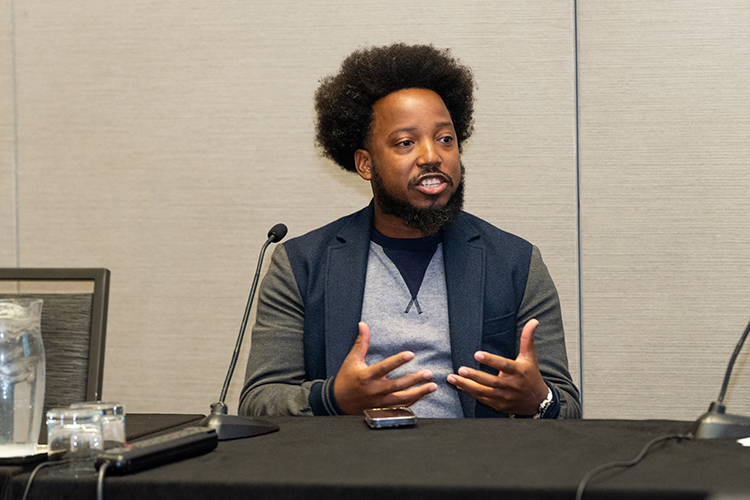 African American man speaking at a conference.