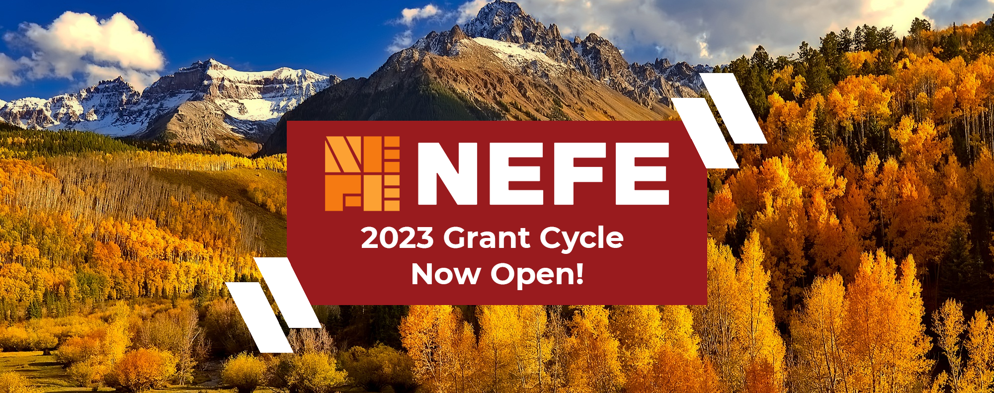 A mountain range with trees and a red sign “NEFE 2023 Grant Cycle Now Open